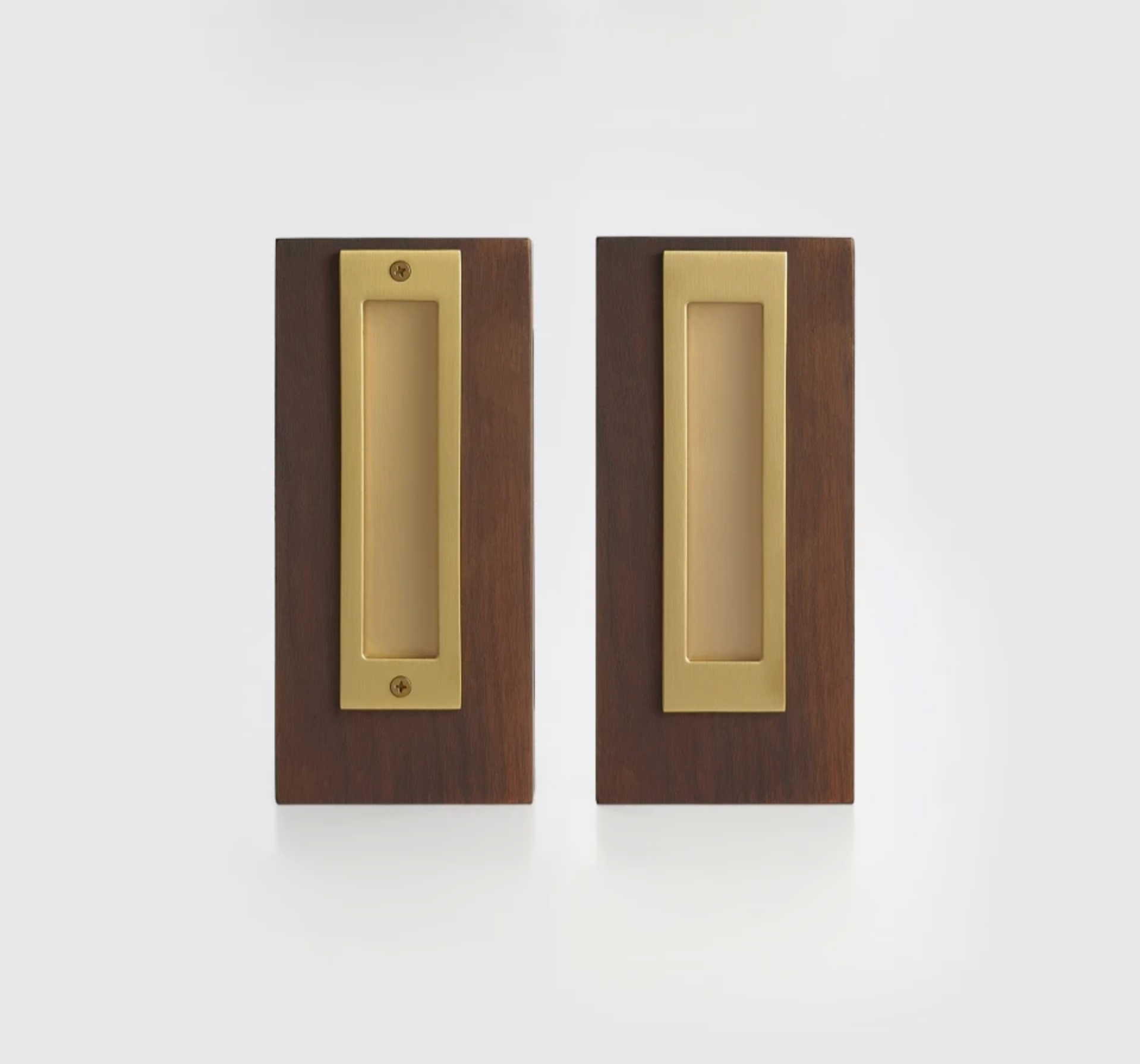 Two matching rectangular pocket door pulls with a brushed brass center plate and a dark brown wood surround, shown side by side on a clean white background.